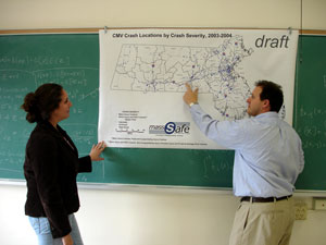 Image of two people discussing map on wall